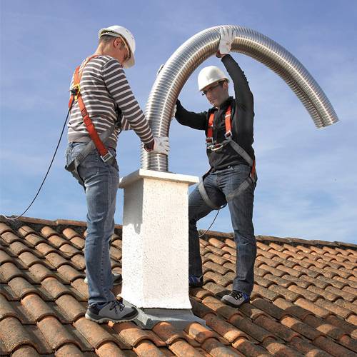 Foto-de-dos-personas-sobre-el-tejado-y-que-instalan-un-conducto-flexible-dentro-de-una-salida-de-tejado-mamposteada